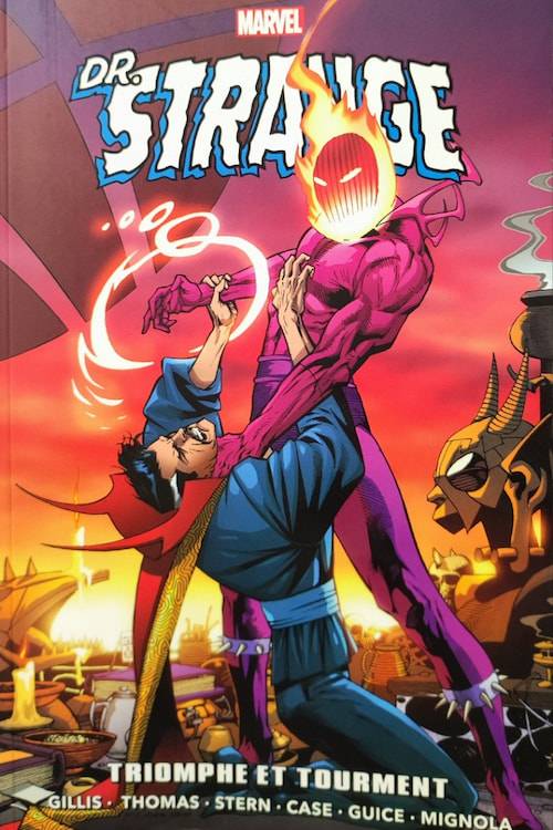 Couverture de comic-book. On y voit une créature humanoïde à la peau violette et à la tête en feu entrain d'étrangler un homme en tenue bleue et avec une grande cape rouge. Le titre est : Docteur Strange, Triomphe et Tourment/