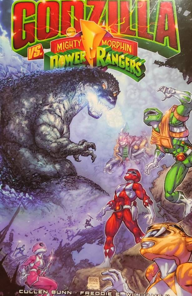 Couverture du comic-book Godzilla VS Mighty Morphin Power Rangers. Le titre est en grand, en rouge et vert. En bas au premier plan, on voit les Power Rangers entrain de regarder lers le milieu de la couverture où il y a godzilla, un lézard géant radioactif.